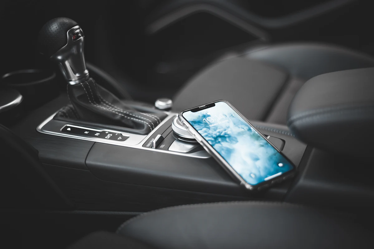 Celular apoyado sobre la consola central de un auto