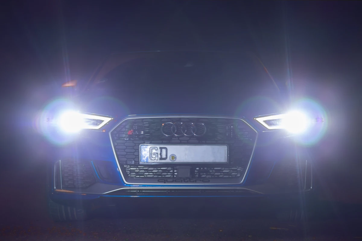 Faros LED encendidos de un auto de noche