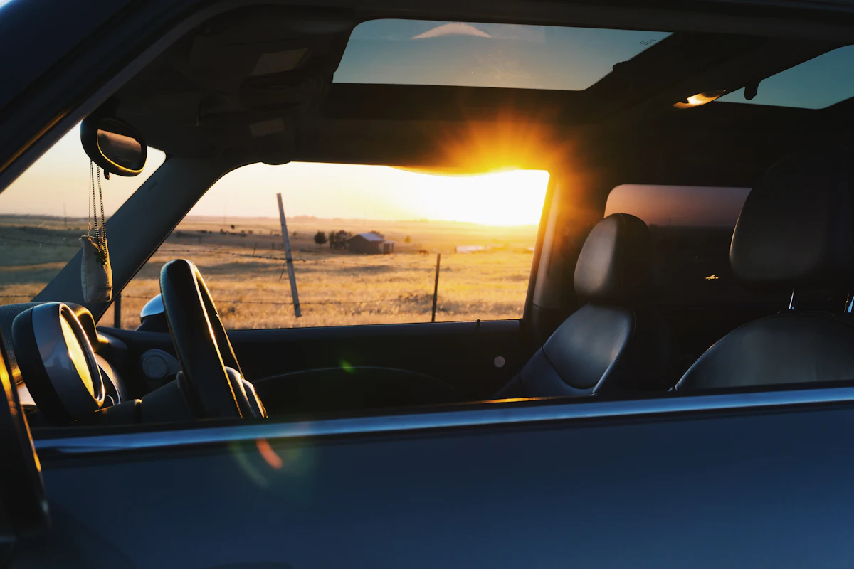 Interior de un auto al atardecer con luz filtrada por las ventanillas
