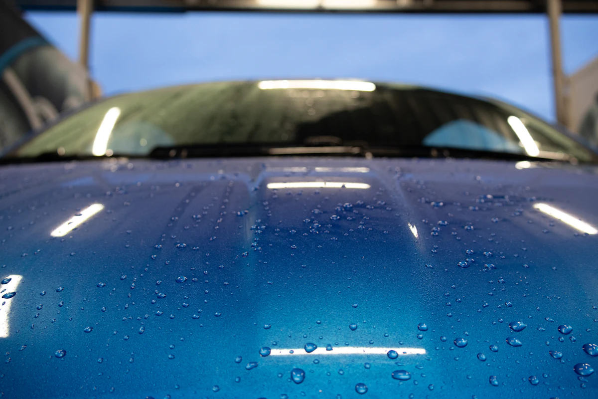 Gotas de agua sobre el capot azul de un auto con superficie hidrofóbica